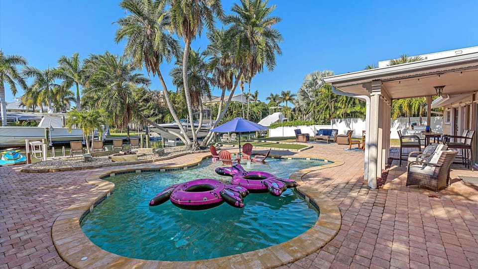 Backyard oasis, heated pool, putting green, pool loungers, and outdoor seating.