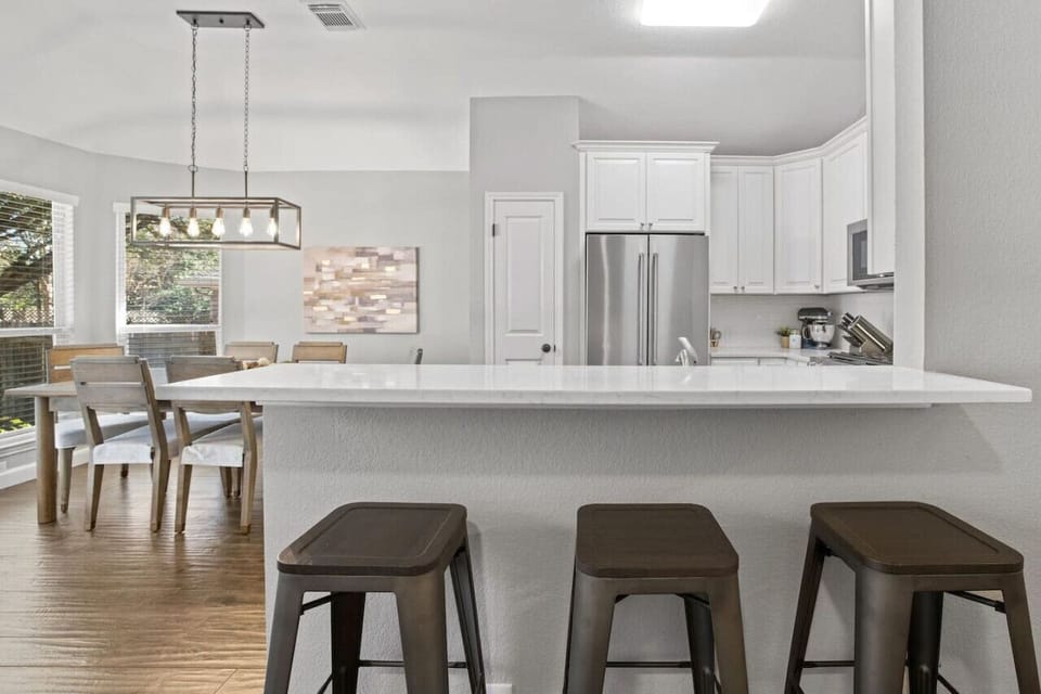 Keep everyone together—open kitchen and dining with bar seating make this cozy Cedar Park home perfect for families and work trips.