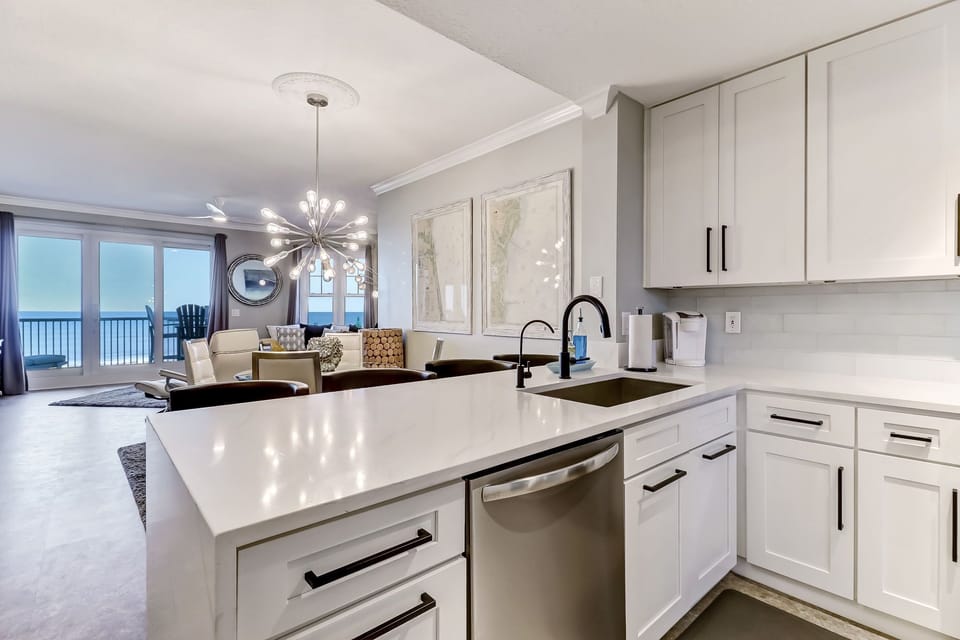 Waterfall Quartz Countertops, Stainless Appliances, Bar Stool Seating for 4 at this Grandeur Kitchen that Opens Up to the Living Space