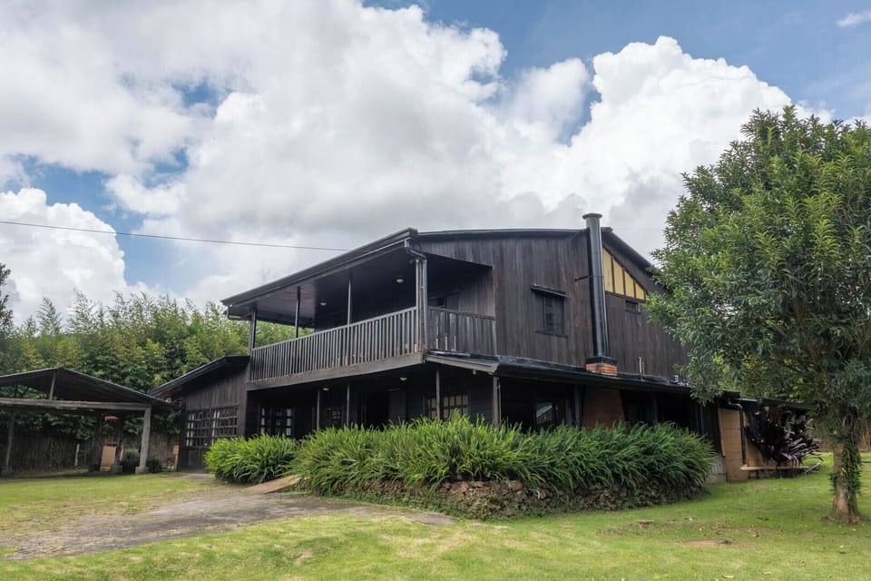 All wooden rustic cabin surrounded by nature and farmland. 