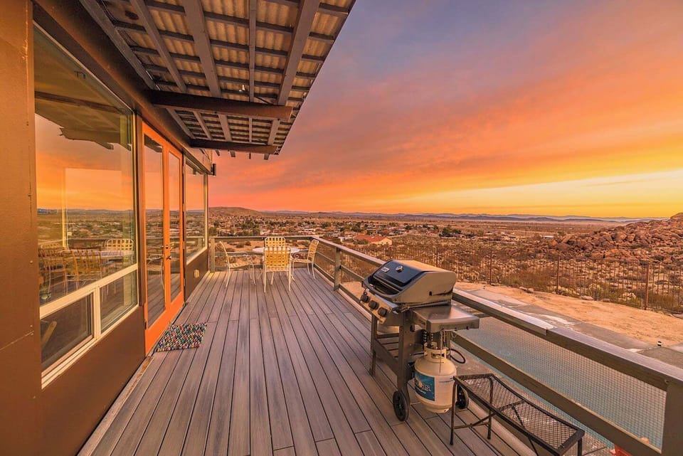 Sunset view from outdoor deck at Casa Altura Joshua Tree vacation rental with gas grill and panoramic desert views.