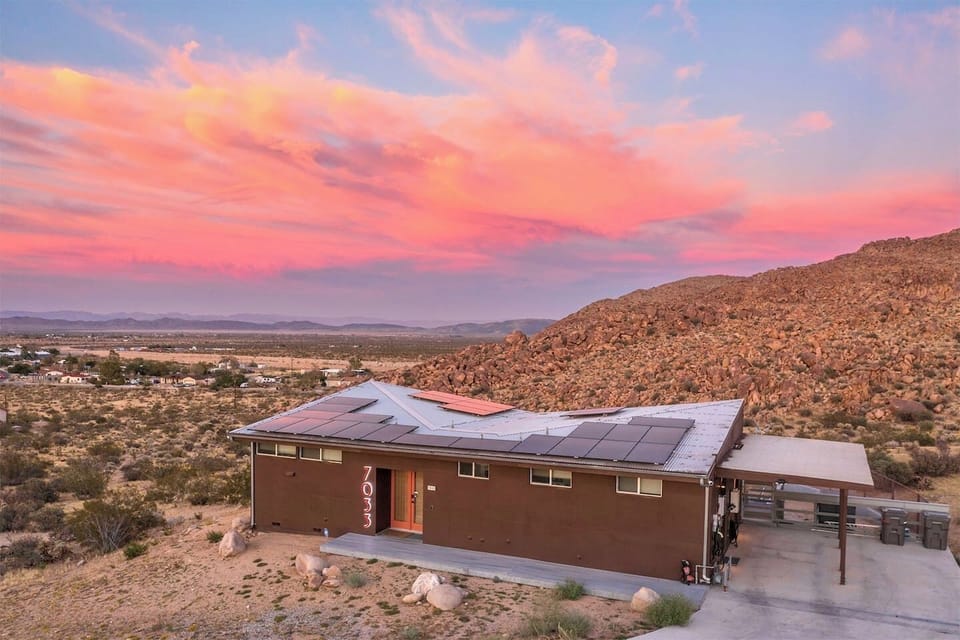 Casa Altura luxury Joshua Tree vacation rental exterior at sunset with panoramic desert and mountain views.