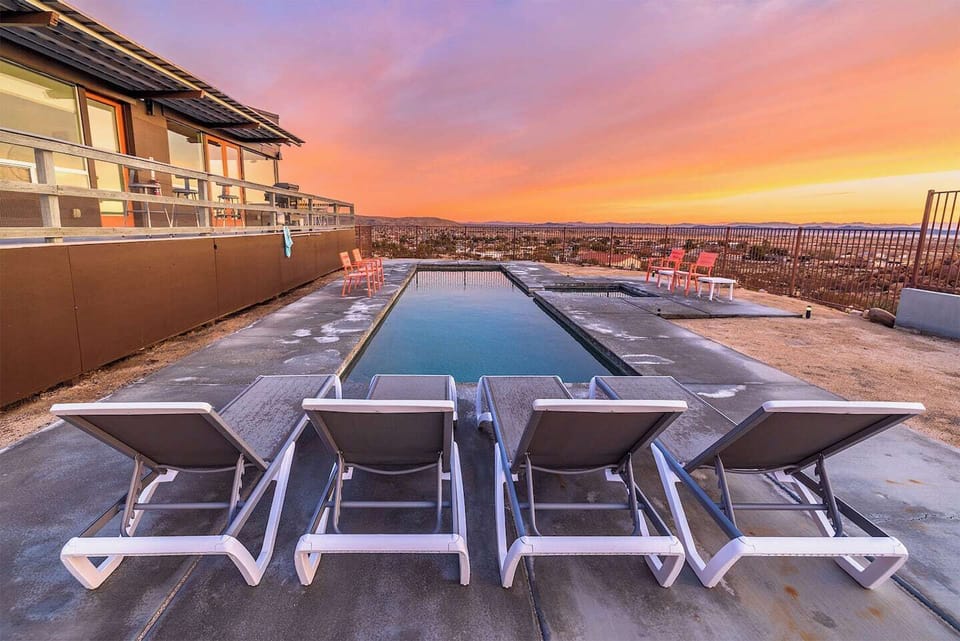 Private pool at Casa Altura Joshua Tree Airbnb with lounge chairs and panoramic desert mountain views.