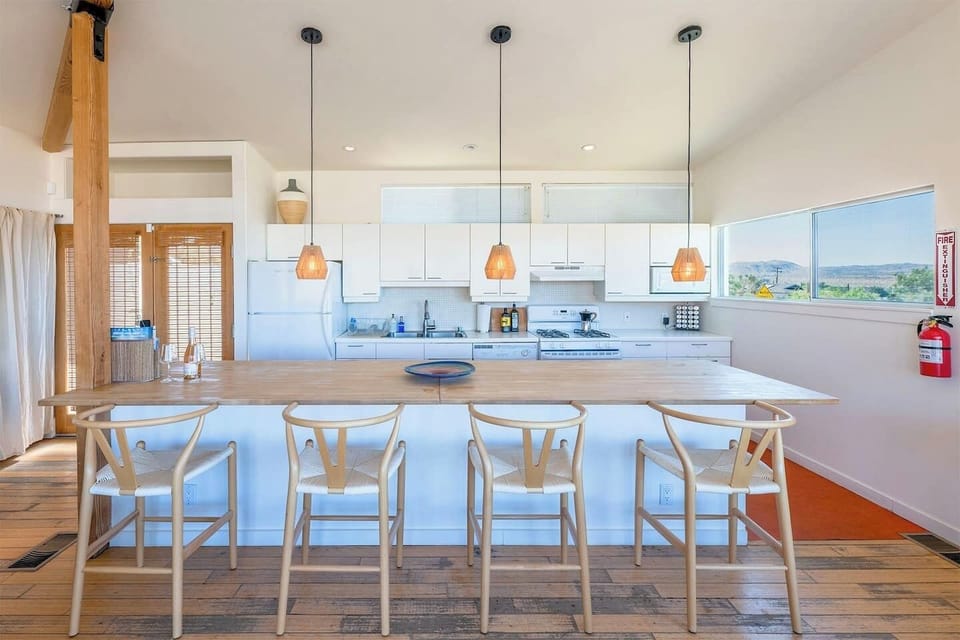 Modern kitchen with island and desert views at Casa Altura Joshua Tree vacation rental.