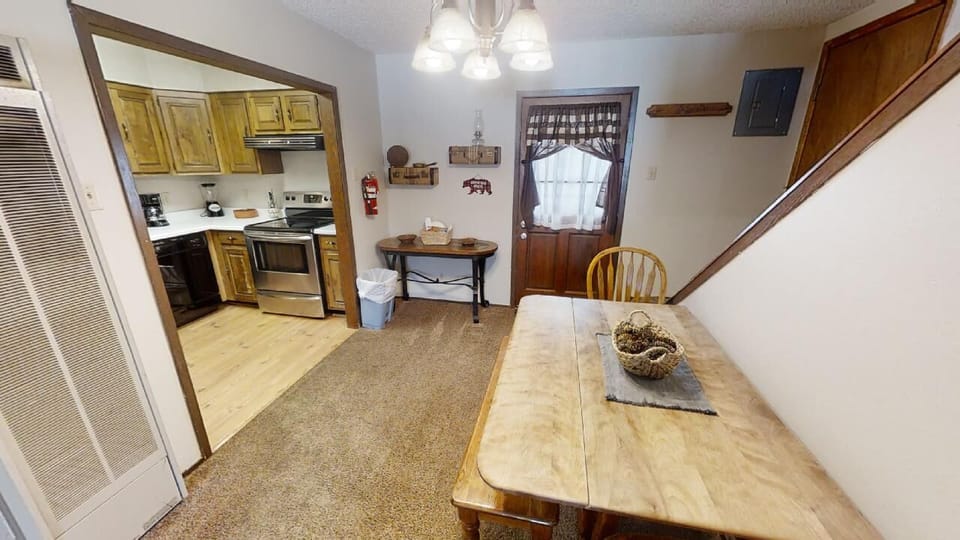 Your fully equipped kitchen with rustic wooden dining table invites you to gather for home-cooked meals and morning coffee in this cozy, welcoming space.