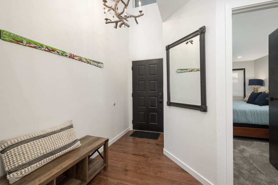 Entryway with two coat hooks and mudroom bench