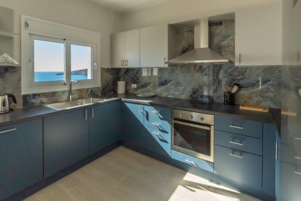 Well-equipped kitchen with dishwasher, laundry machine, and a view of the sea.