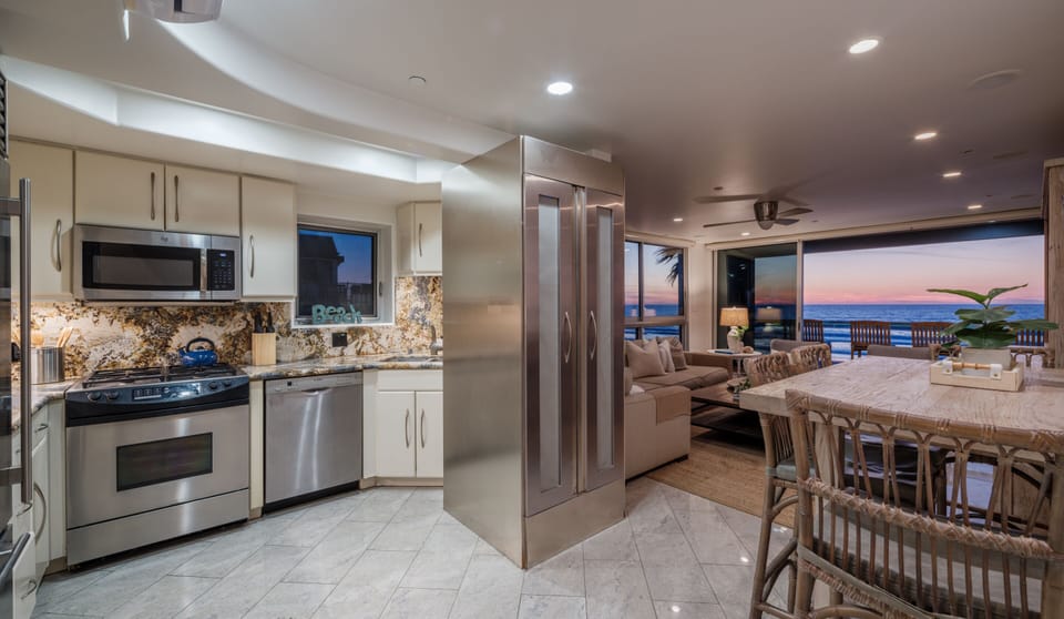 This contemporary kitchen boasts high-end stainless steel appliances, premium cookware, and all the utensils needed for a perfect stay.