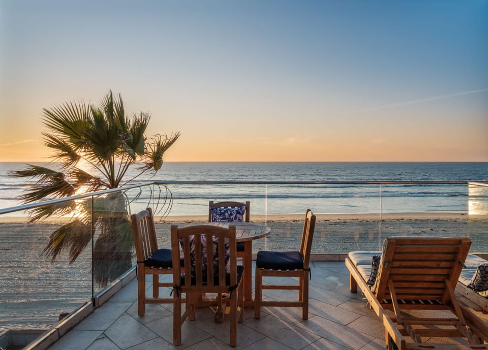 This spacious rooftop deck features luxurious outdoor furniture and breathtaking sunset views.