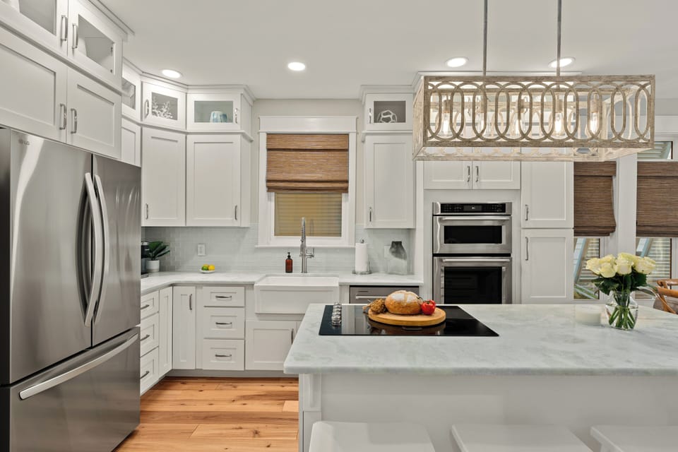 Detailed view of the chef’s kitchen with white cabinetry and a double oven.