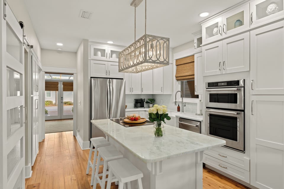 Modern kitchen featuring a marble island and stainless steel appliances.