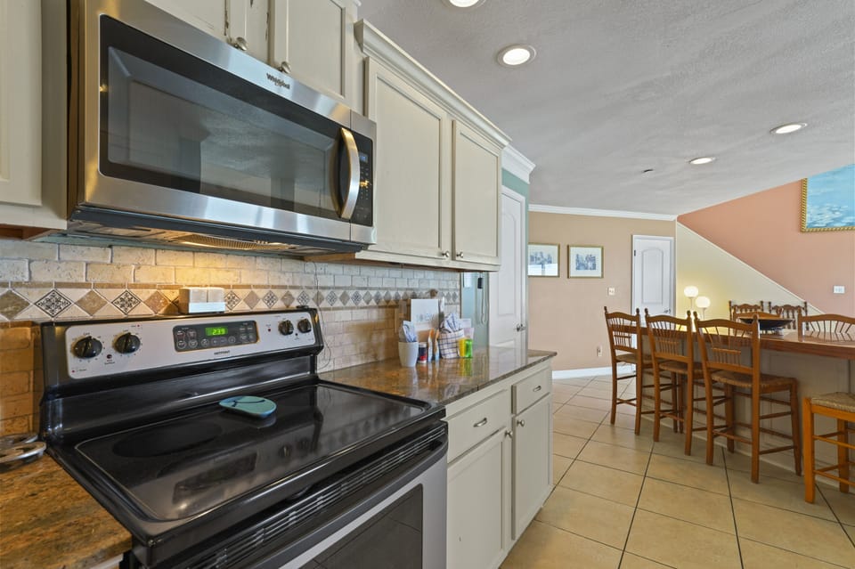Open-concept coastal kitchen with bar seating and stainless steel appliances at Cabana Club 401.