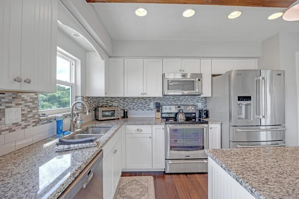 - Bright and clean kitchen offers extra counter space and quality appliances
- Glass tile backsplash and modern lighting highlight the chef ready setup
- All the essentials are here for morning coffee or full holiday feasts