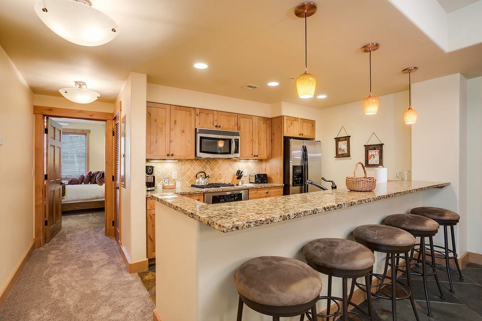 Your spacious kitchen awaits with granite countertops, modern appliances, and a breakfast bar perfect for morning coffee or casual meals together.