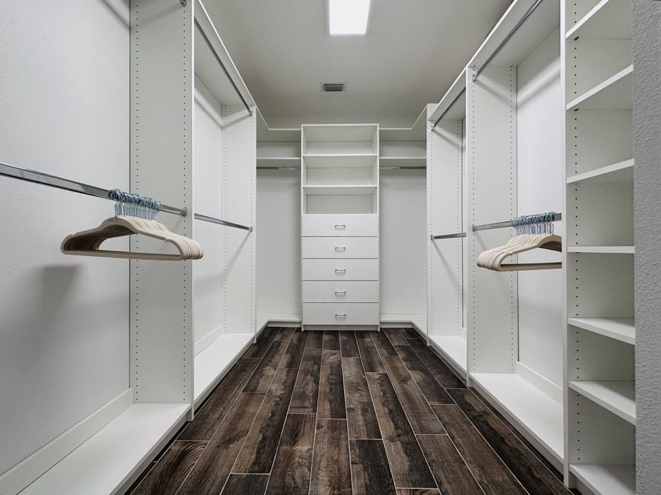 Walk in closet in the master bathroom with built it shelves