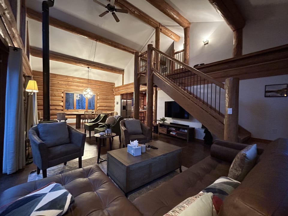 Living room with staircase to upstairs and dinning room view.
