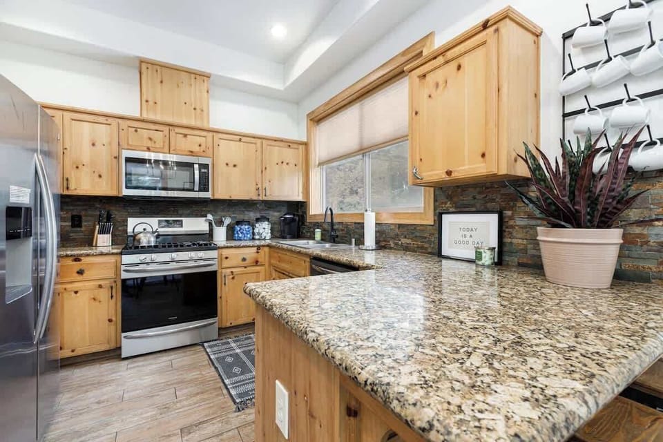 Fully stocked kitchen with gas range, full size fridge, and plenty of counter space