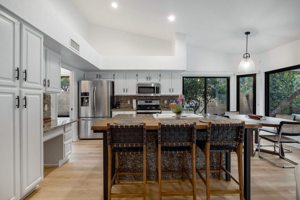 Updated open plan kitchen and breakfast nook with views out to the pool and backyard.