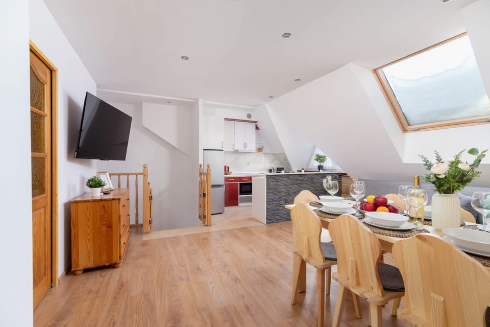 A bright kitchen and dining area with a skylight, blending natural and modern touches.
