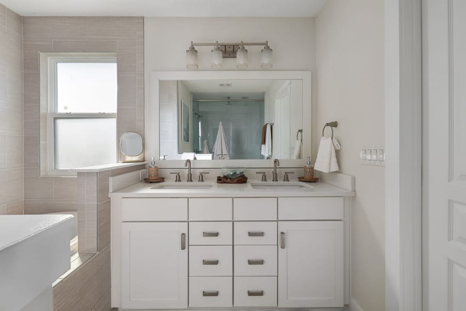 Spacious primary ensuite with double vanities and plenty of space to get ready.  A bright, comfortable bathroom connected to the main bedroom.