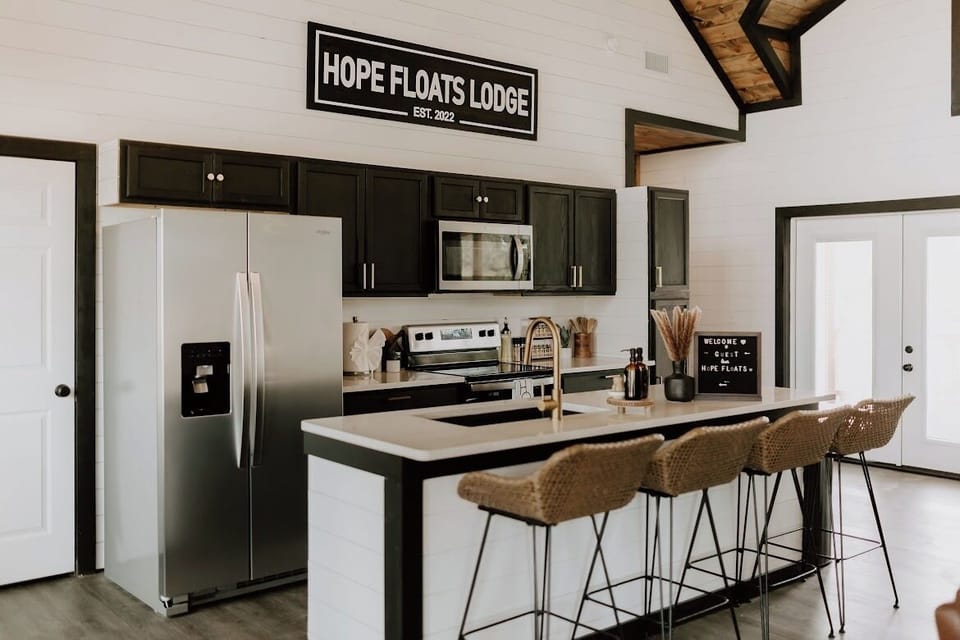 A chef’s dream at Hope Floats. Our fully equipped kitchen features sleek black cabinetry, gold accents, and a breakfast bar perfect for morning coffee or evening cocktails.