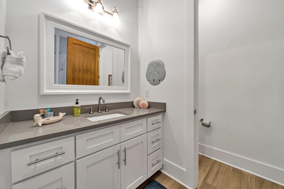 Main Floor Mermaid Bathroom with ample storage, toilet, and tile shower