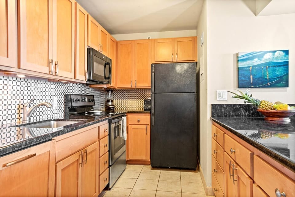 This modern kitchen offers everything you need—sleek appliances, rich wood cabinetry, and coastal charm throughout    