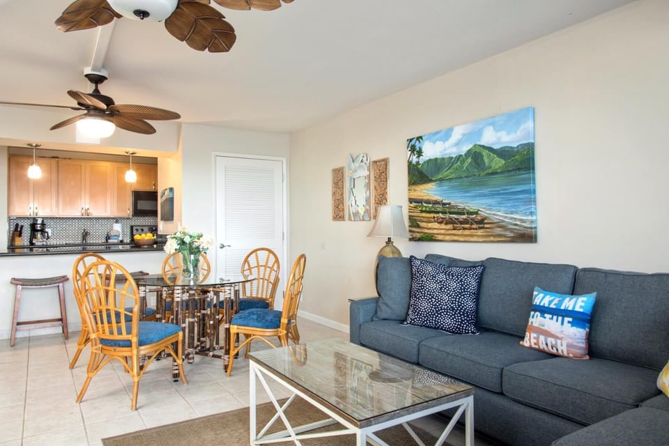 Relax in the living room where palm-leaf fans, plush seating, and coastal charm create the ultimate beachy vibe   