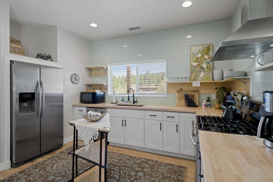 Kitchen has stainless steel appliances and is fully stocked