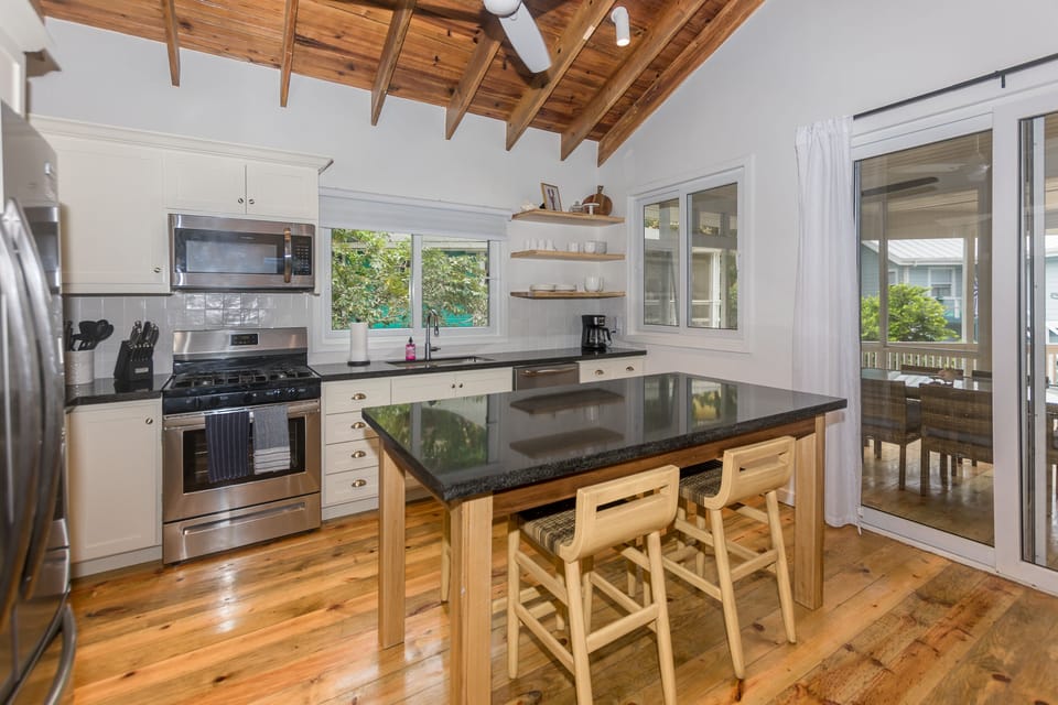 Open kitchen with cathedral ceilings and an island with seating for 4 people 