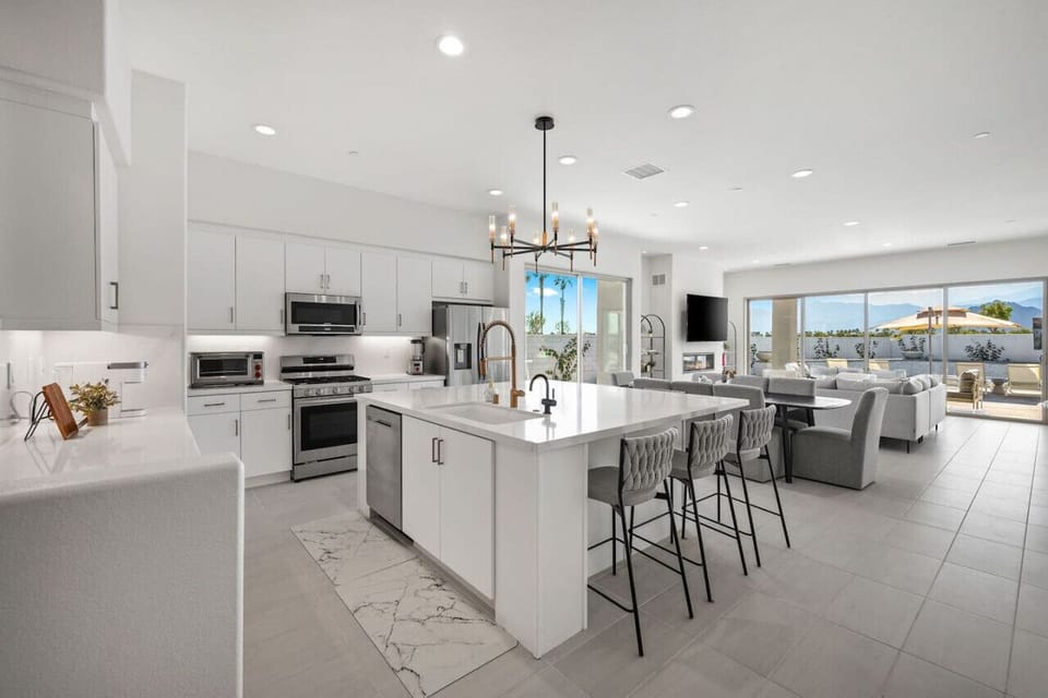 Stylish white kitchen w/ oversized island & bar seating for easy gatherings.