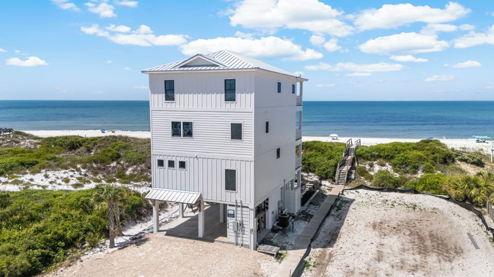 Waterfront vacation home positioned directly on pristine beach with private walkway access to white sand shores.