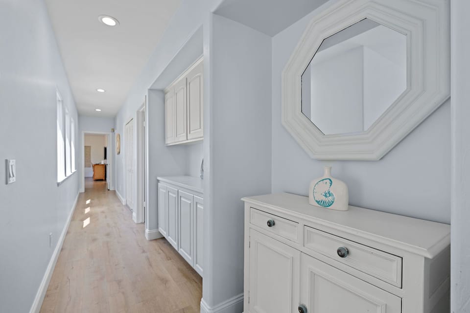 Hallway with coastal charm that connects to the bedrooms