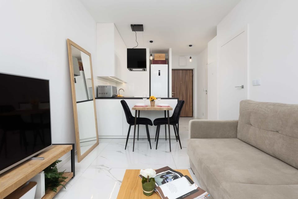 A dining area featuring a table, chairs, and a large mirror on the wall.
