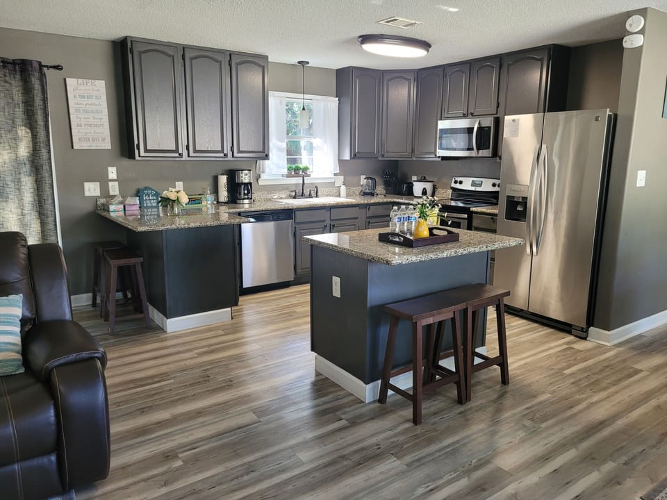 A cozy kitchen/ dining room combo with island and  4 stools.