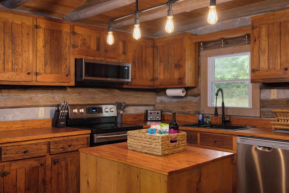 Rustic cabin kitchen with warm wood finishes, island, and modern appliances