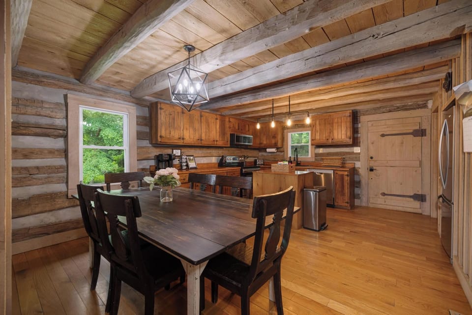 Rustic log cabin kitchen and dining space with warm wood finishes