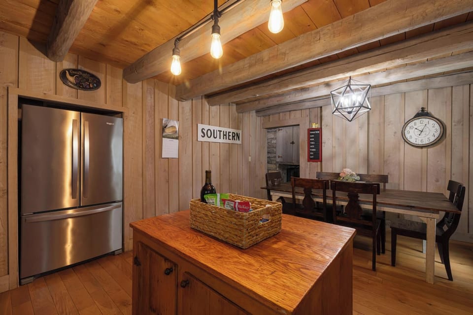 Cozy rustic kitchen with wood beams, island, and inviting dining space