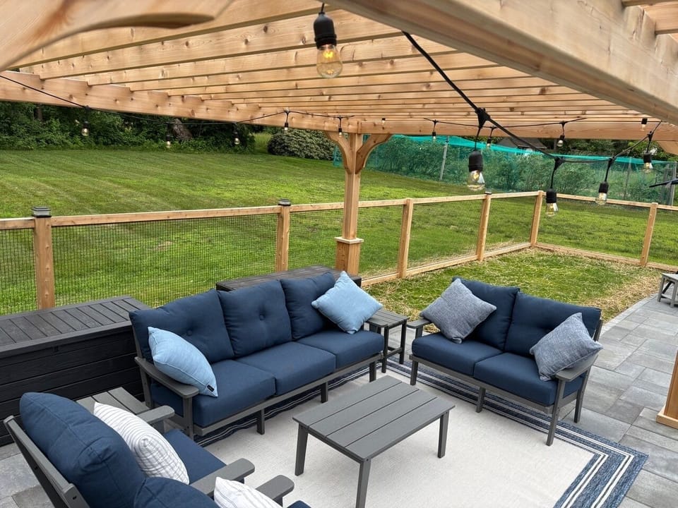 Enjoy the seating area under the pergola next to the pool.