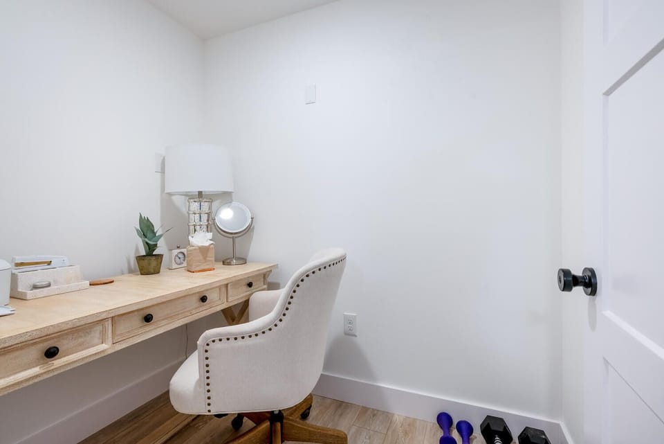 Home office with printer, desk, chair and separate room.