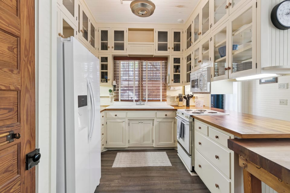 Your fully equipped kitchen features warm wood countertops, classic white cabinetry, and everything you need to prepare memorable meals together.