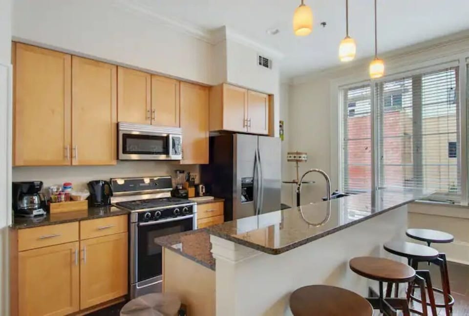 Modern kitchen equipped with stainless steel appliances and granite countertops.