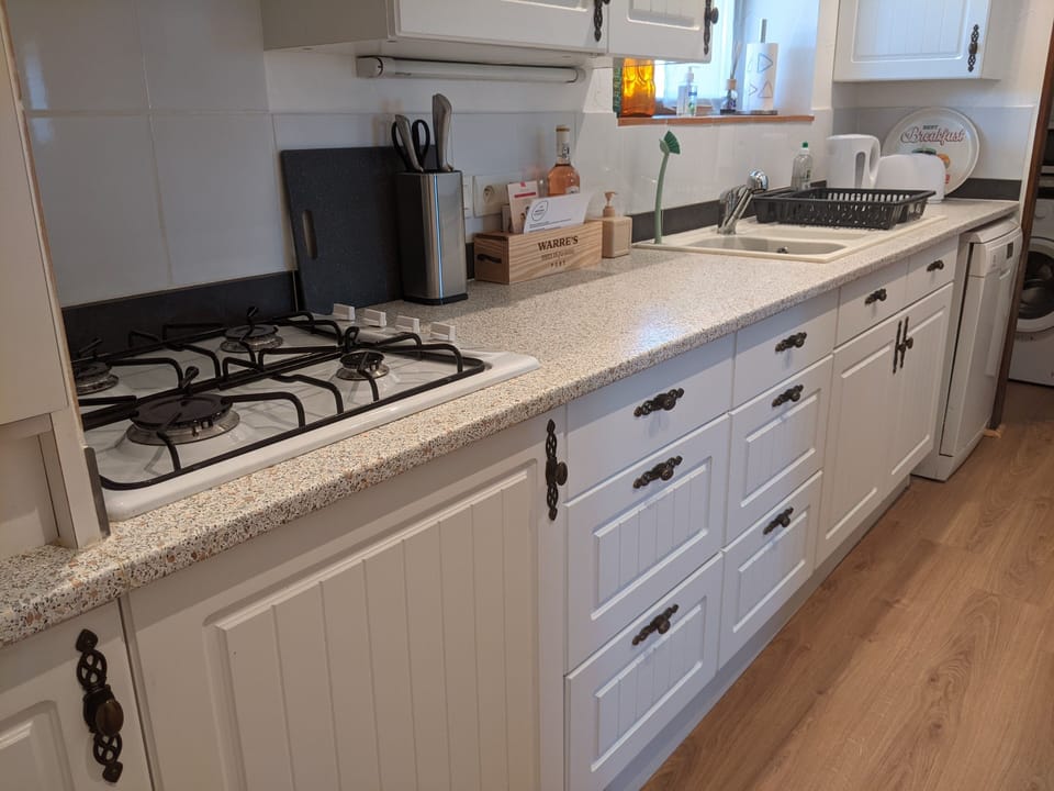 Kitchen area with oven, hob, dishwasher and washing machine.