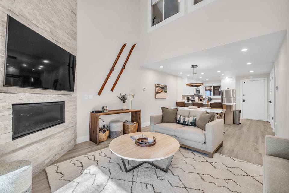 Living room: Couch, 2 chairs, gas fireplace, 70” TV, access to balcony
