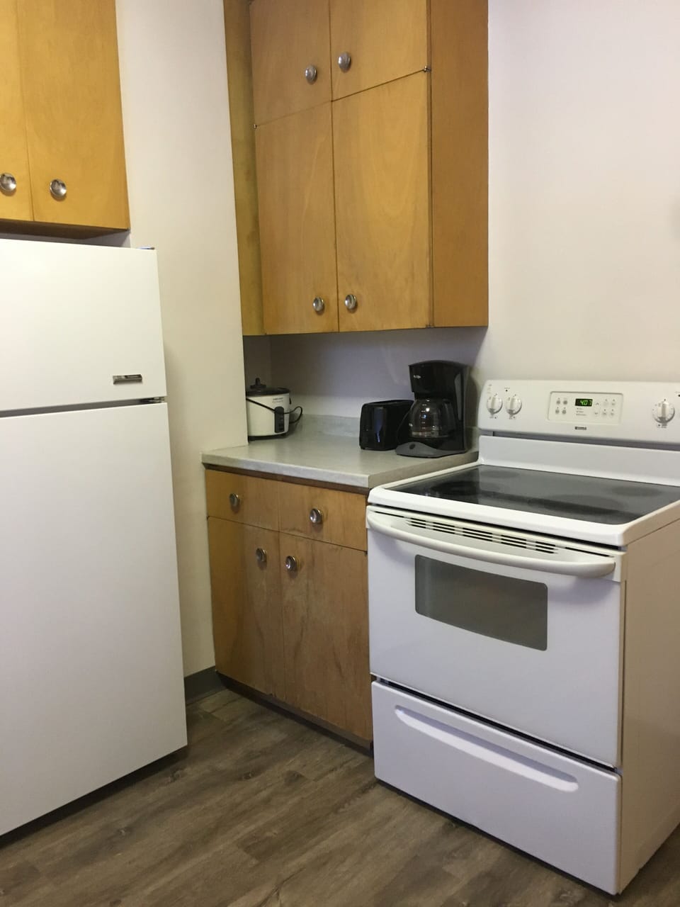Full kitchen with vintage cabinets and fixtures.