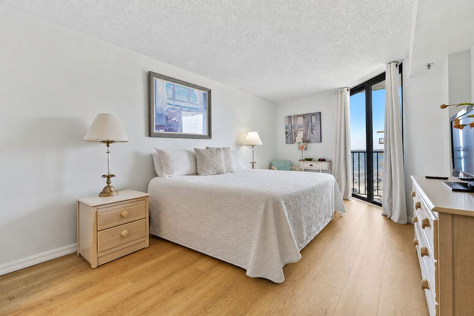 Relax in a bright king bedroom with coastal décor, a Smart TV, and beautiful ocean views.