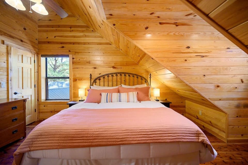 This king suite in our cabin features a plush king-sized bed dressed in a coral colored quilt. This stylish and inviting space will have you never wanting to leave.