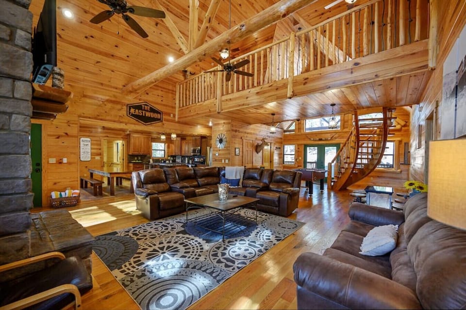 Our cabin`s living room boasts a spacious and open layout, complete with a soaring ceiling and large windows. The comfortable furnishings and stone fireplace make this room a cozy and inviting space.