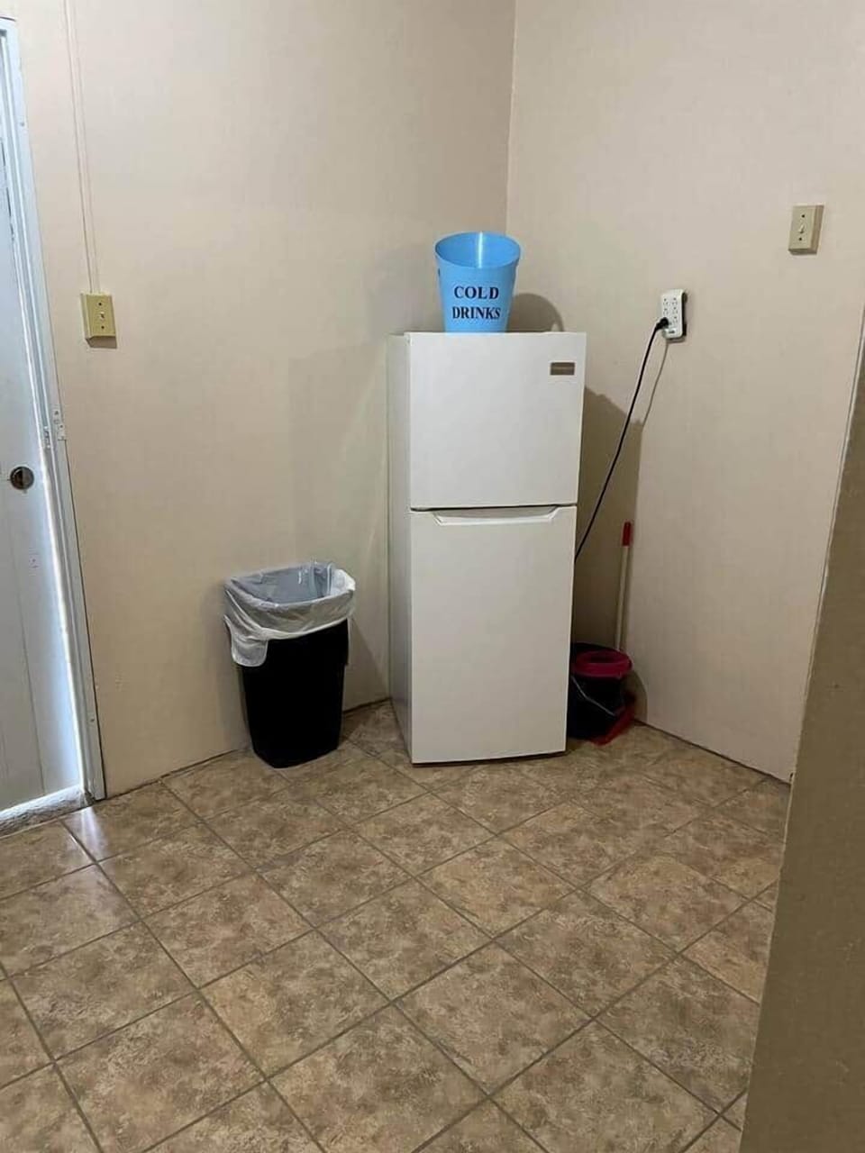 Full kitchen with a refrigerator, microwave, coffee maker, and cooking set.