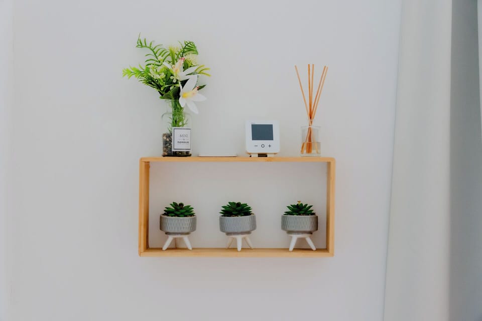 Minimalist wall shelf with succulents, diffuser, and fresh florals